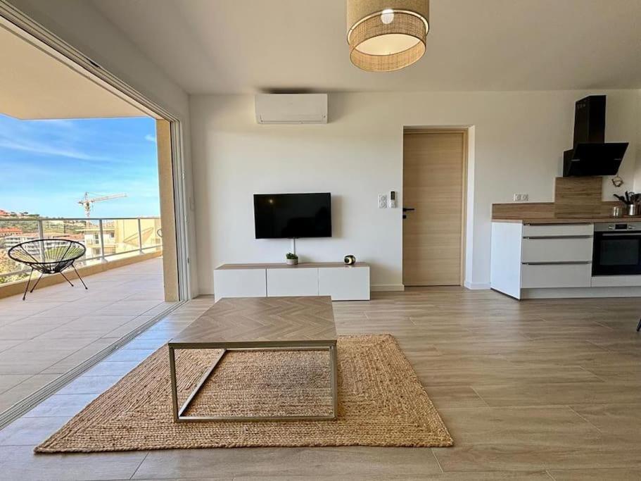 - un salon avec vue sur la cuisine dans l'établissement Superbe appartement neuf 4pers, à LʼÎle-Rousse
