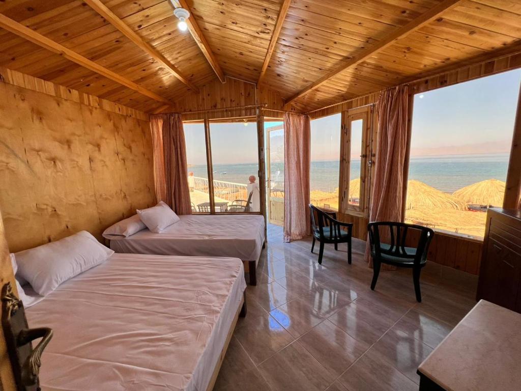 a room with two beds and a view of the ocean at Panorama Lodge Nuweiba in Nuweiba