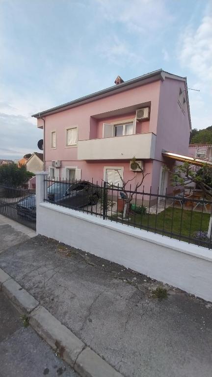 una casa rosa con una valla delante en JAN3 en Pula