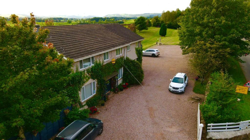 an aerial view of a house with two cars parked in a driveway at Southpark House in Dumfries