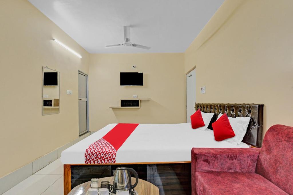 a bedroom with a bed and a red chair at Flagship Sri Jagarnath Banquet & Hotel in Rānchī