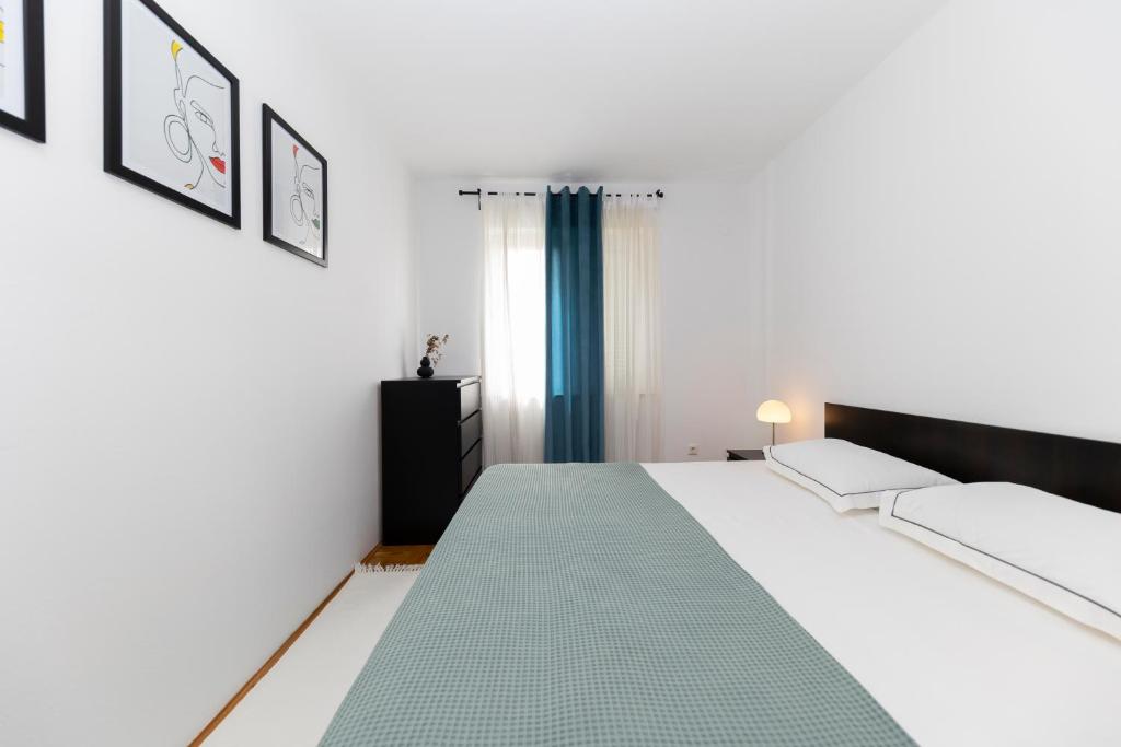 a bedroom with a large white bed and a window at Apartment Nea Zadar in Zadar