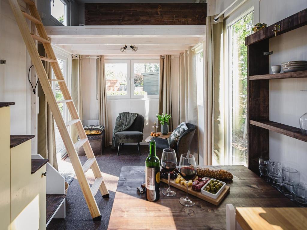 una habitación con una mesa con botellas de vino y copas en vakantiehuisje Tiny house met sauna in de bossen van de Veluwe en Putten