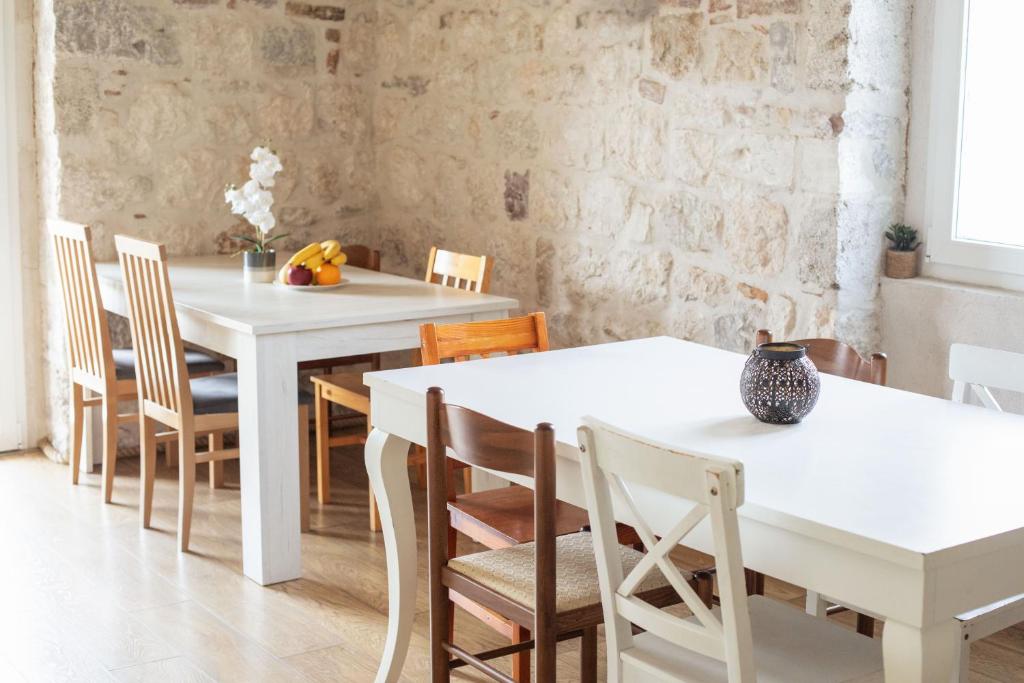 Un comedor con mesas y sillas blancas. en Step to Kotor bay Guesthouse, en Kotor