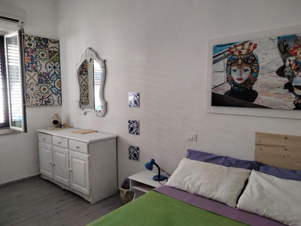 ein Schlafzimmer mit einem Bett und einem Wandgemälde in der Unterkunft Casetta Blu Mondello zona Partanna in Palermo