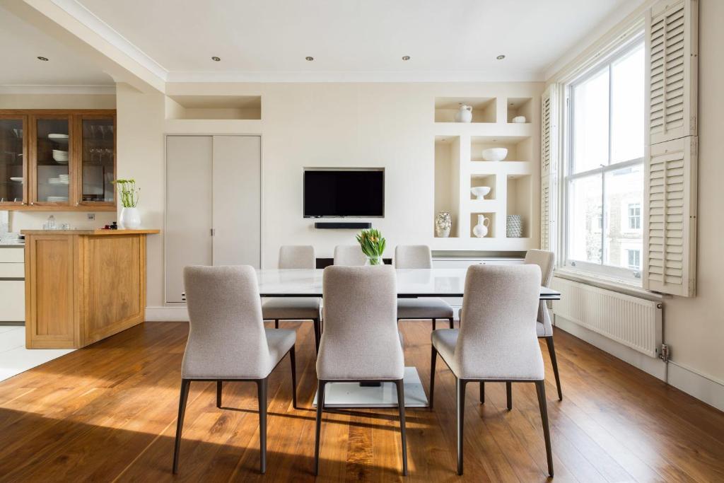 uma cozinha e sala de jantar com mesa e cadeiras em Light-filled Chelsea Duplex em Londres