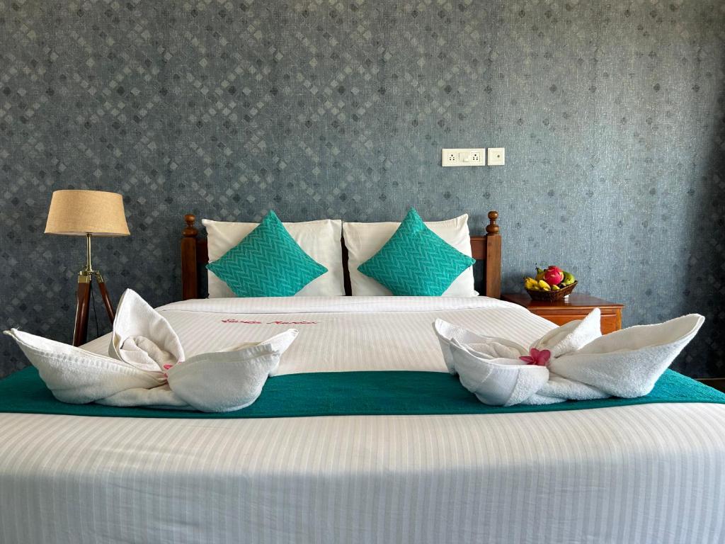 a bed with three white pillows on top of it at Sunset and Palm trees - An Airport Boutique by the Sea in Trivandrum