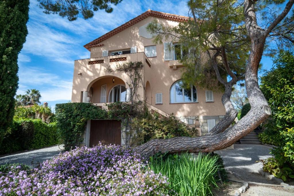 a house with a large tree leaning over it at GuestReady - A Mediterranean chic escape in Antibes