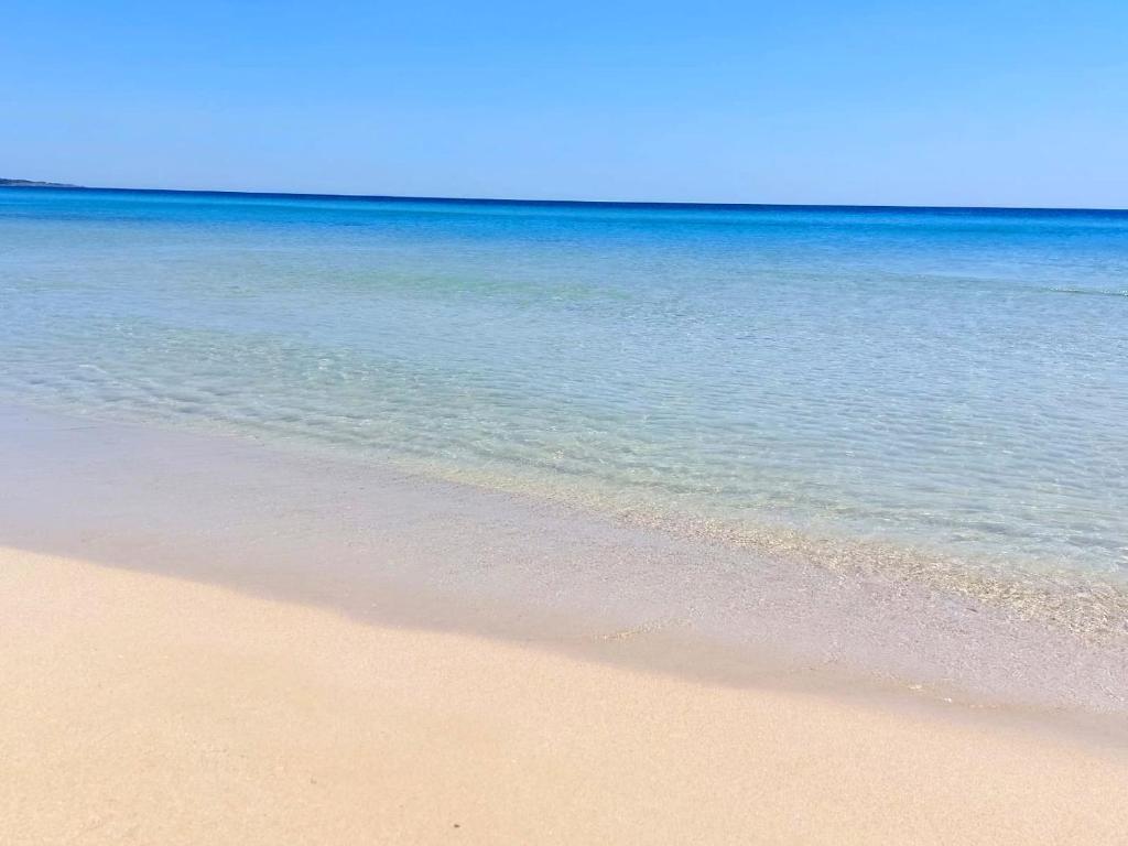 a sandy beach with the ocean in the background at Bilocale per l'affitto estivo in Torre Pali