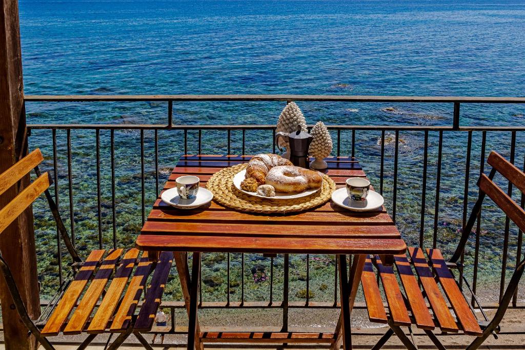 einen Tisch mit einer Schüssel Essen auf dem Balkon in der Unterkunft Acquamarina Home in Giardini-Naxos