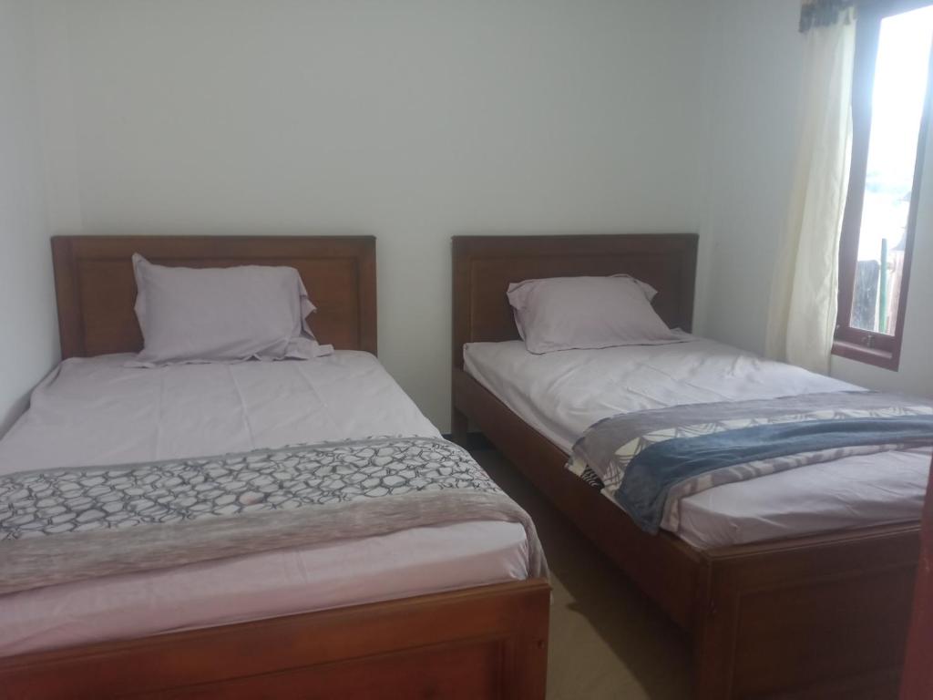 dos camas sentadas una al lado de la otra en un dormitorio en THE TWINS HOMESTAY, en Rantepao