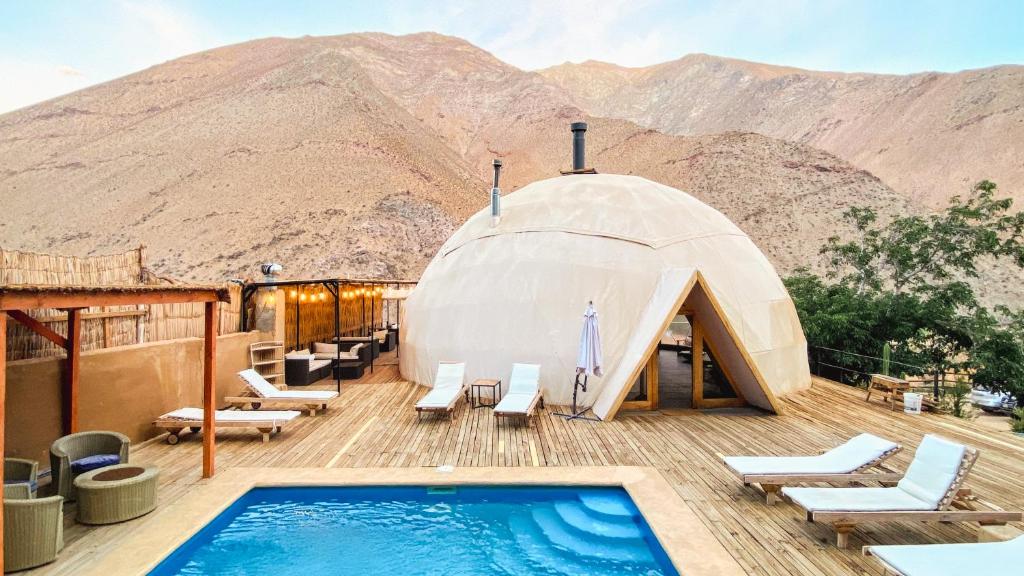 a dome house with a swimming pool on top of a mountain at Milodge Elqui Domos in Pisco Elqui