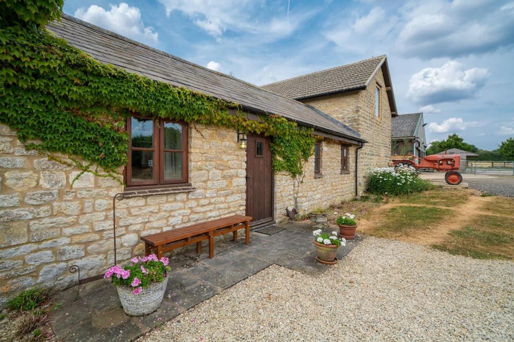 una casa de ladrillo con un banco delante de ella en Carters cottage, en Buckinghamshire