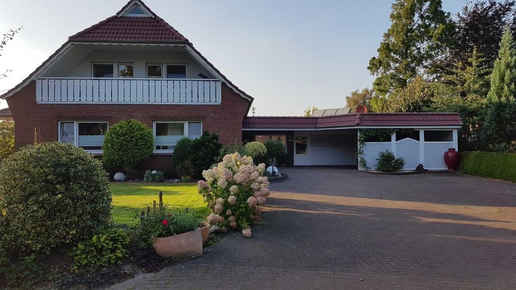 a red brick house with a white garage at Ferienwohnung Am Moorweg in Ihlow