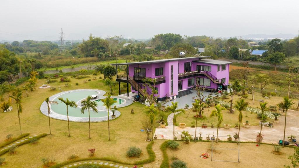 a pink house with a playground in front of it at VIOLET VILLA in Hòa Bình