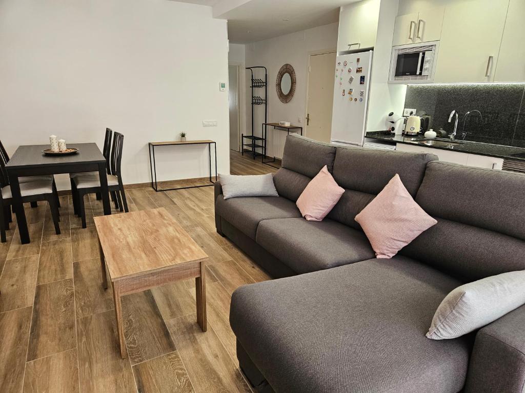 ein Wohnzimmer mit einem Sofa und einem Tisch in der Unterkunft Apartament LA SAL in Pineda de Mar