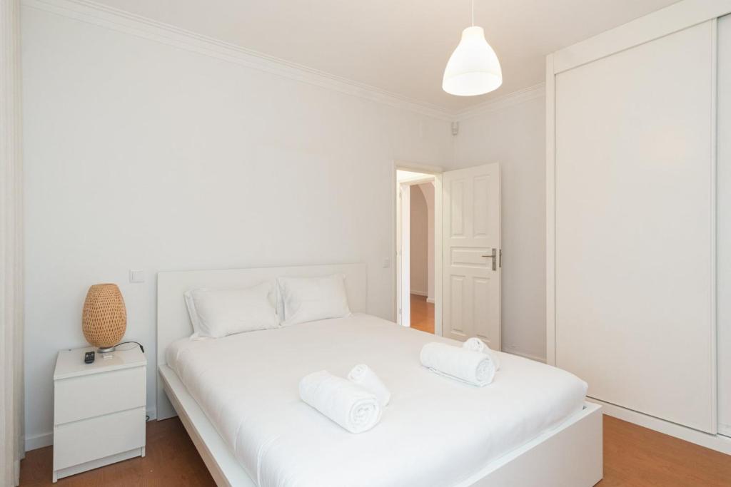 ein Schlafzimmer mit einem weißen Bett mit zwei Handtüchern darauf in der Unterkunft GuestReady - Marinhas Beauty near Esposende Beach in Esposende