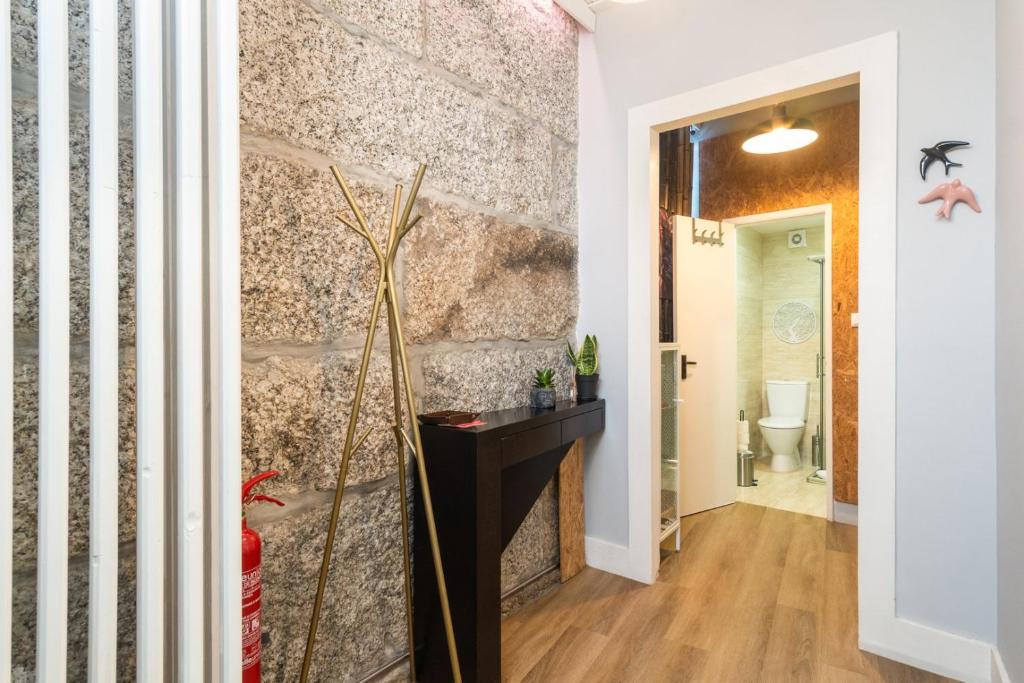 um corredor com uma parede de pedra e uma lareira em GuestReady - Guimarães Urban Retreat em Guimarães