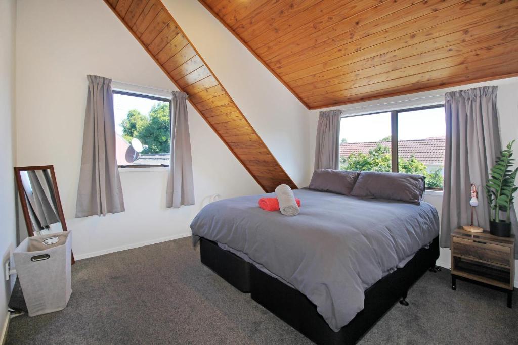 - une chambre avec un grand lit et des fenêtres dans l'établissement Central Studio, à Auckland