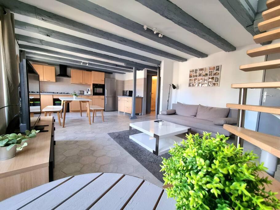 ein Wohnzimmer mit einem Sofa und einem Tisch in der Unterkunft Duplex de l'Arbre de la Liberté in Guebwiller
