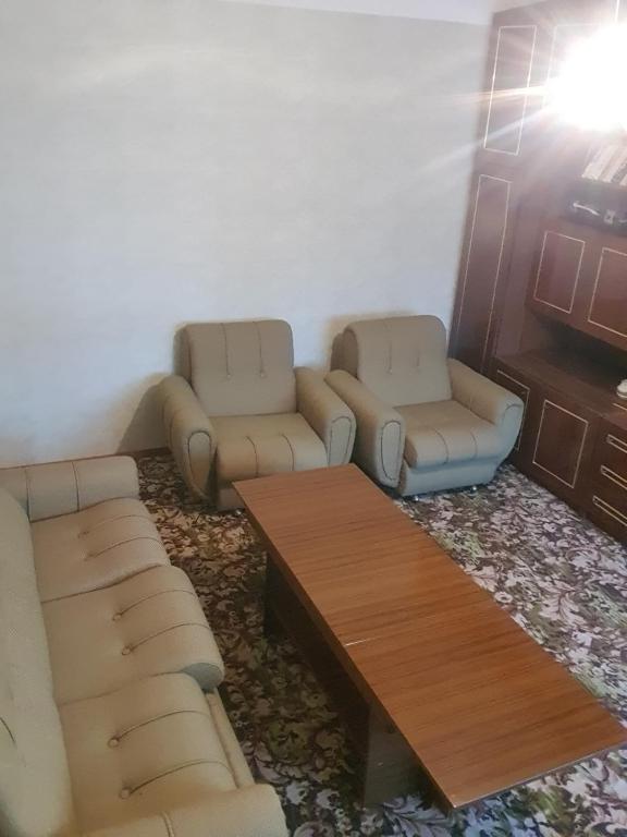 Sala de estar con sofás y mesa de centro en Нощувки вип класа, en Razgrad