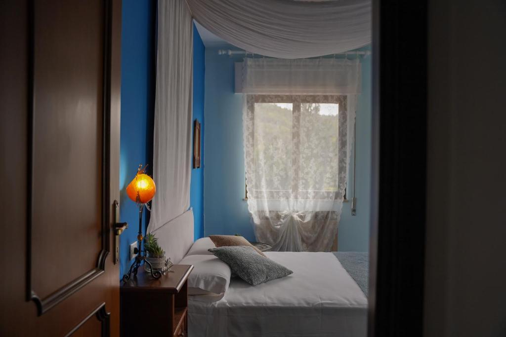 a blue room with two beds and a window at Casa Vicino in Cantalupo Ligure