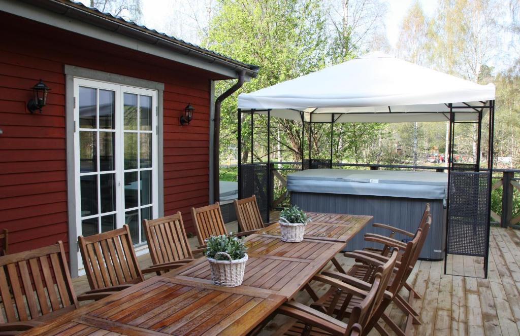 um pátio com uma mesa e um guarda-chuva branco em Kyrkekvarn Stugby em Sandhem