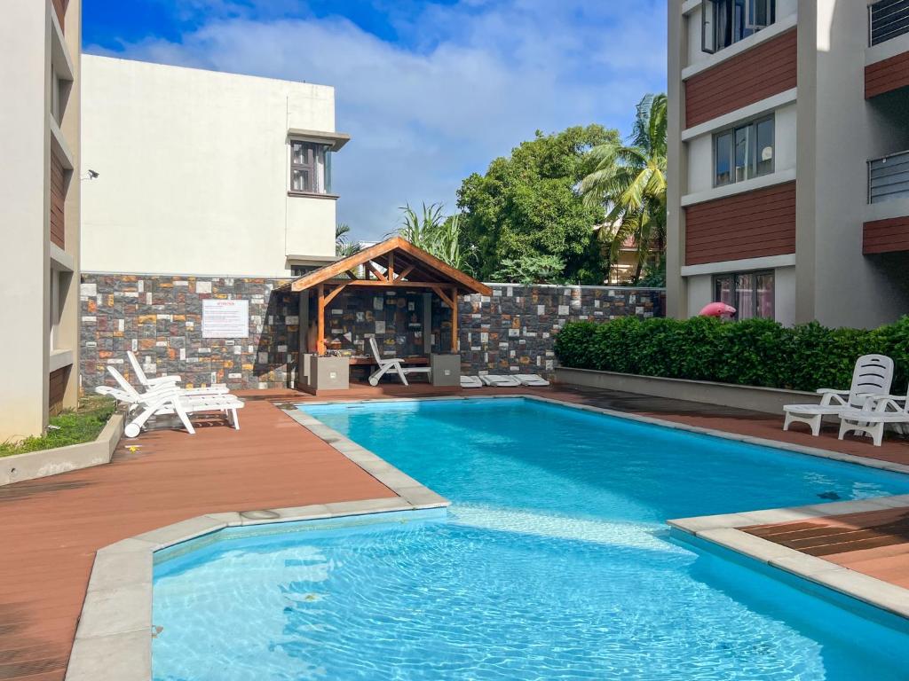 a swimming pool in front of a building at Beachwalk Residence - Trou-aux-Biches in Trou aux Biches