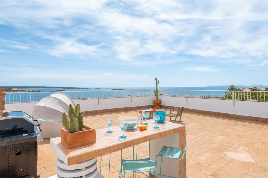 a table on a balcony with a view of the ocean at Beachfront Penthouse in Colònia De Sant Jordi