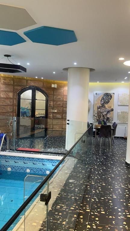 a swimming pool with a table and chairs in a building at شقة مفروشة فاخرة in Al Ḩawīyah