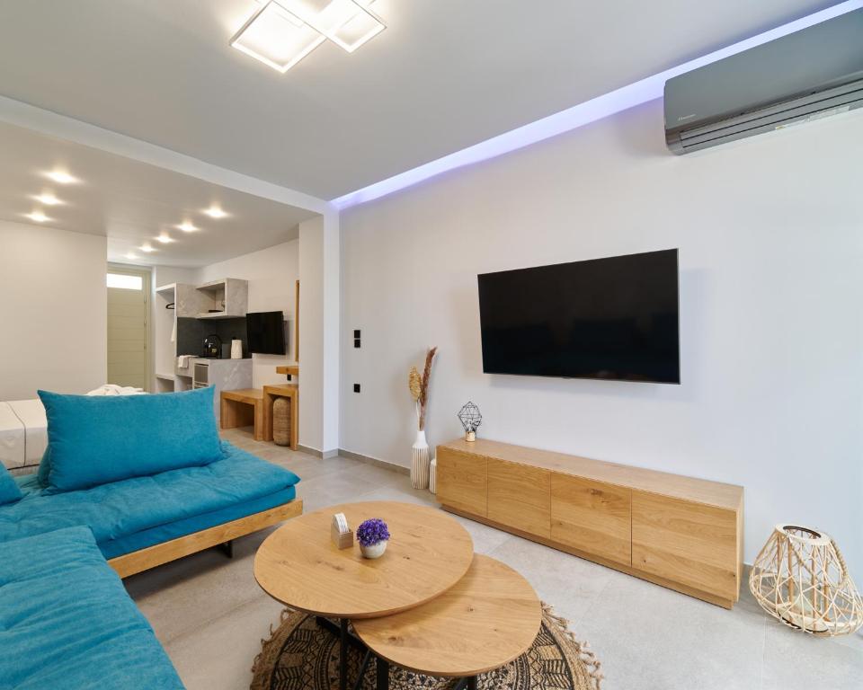 a living room with a blue couch and a table at Sapphire Kythnos Suites in Mérikhas