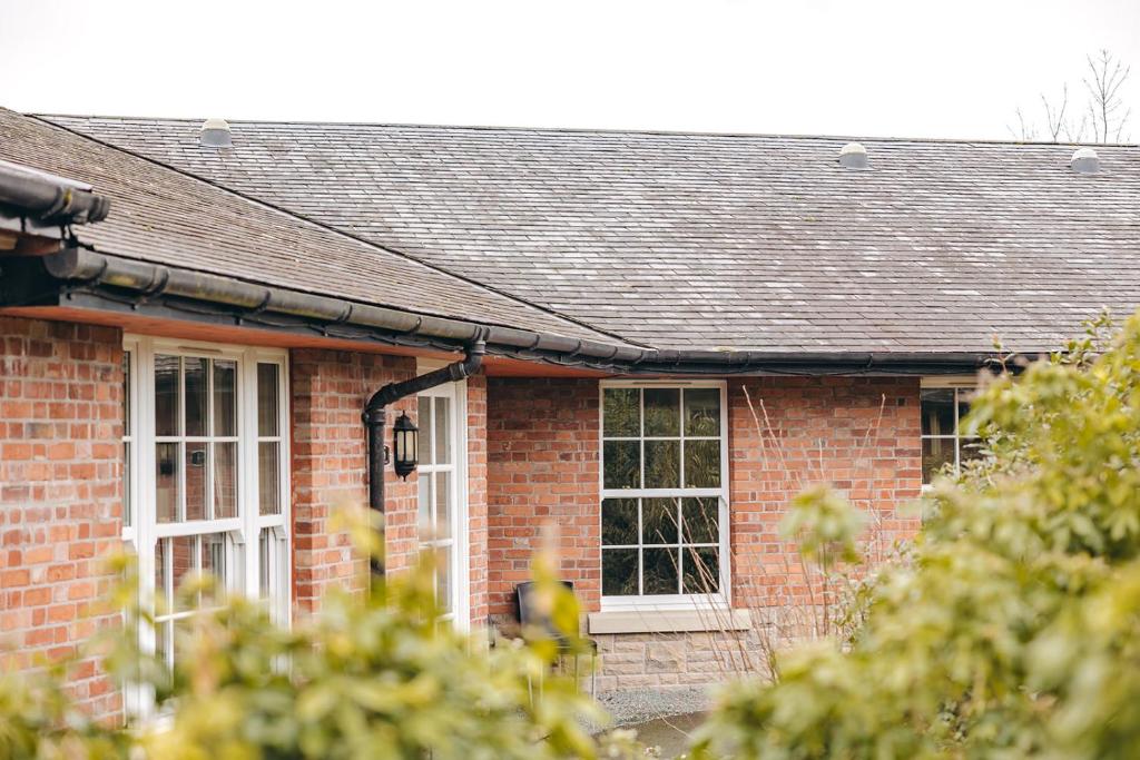 a brick house with white windows and a roof at Finest Retreats - Netley Hall - Rosemary in Dorrington