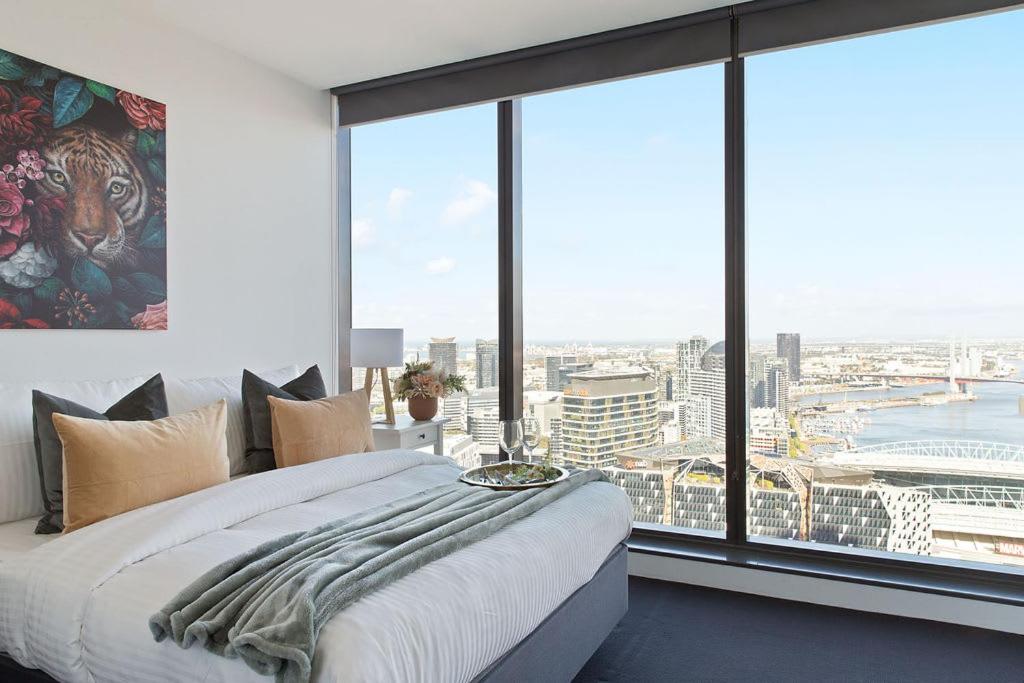 a bedroom with a bed and a large window at A Modern 2BR Apt with Harbour Views FREE Parking in Melbourne