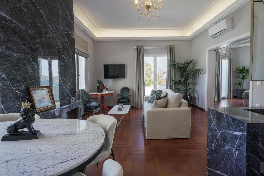 a living room with a table and a couch at Pafsilipon Suites in Ermoupoli