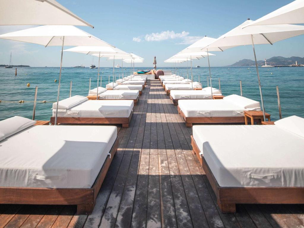 een rij bedden op een dok in het water bij Mondrian Cannes in Cannes