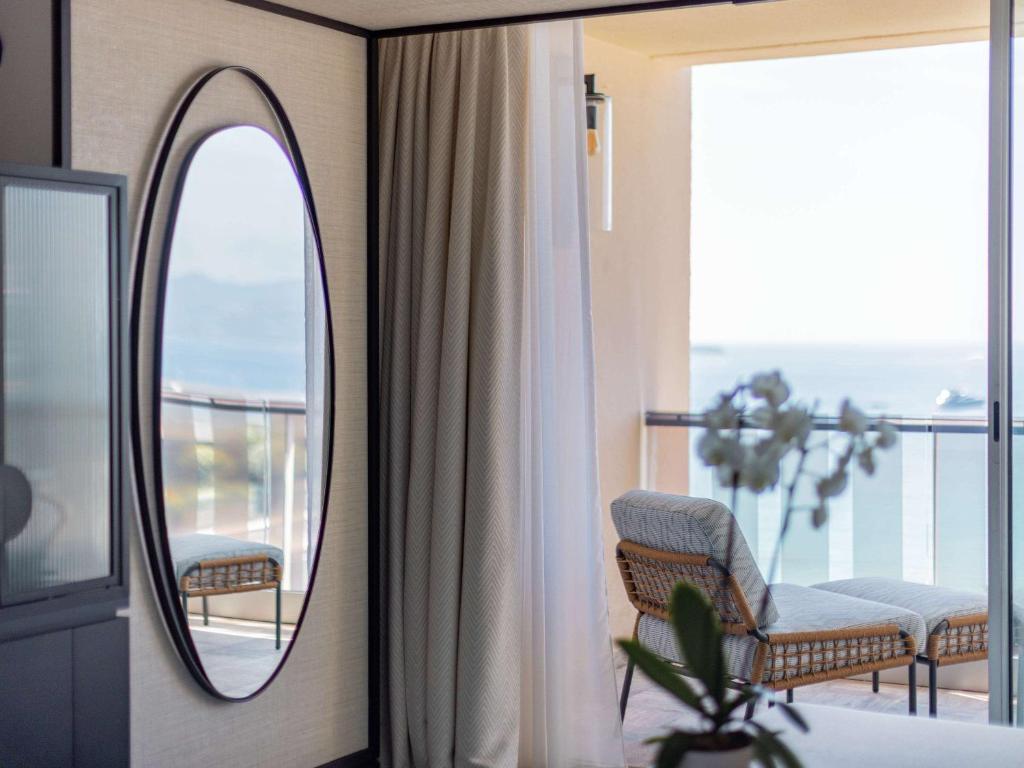 a bathroom with a mirror and a chair on a balcony at Mondrian Cannes in Cannes