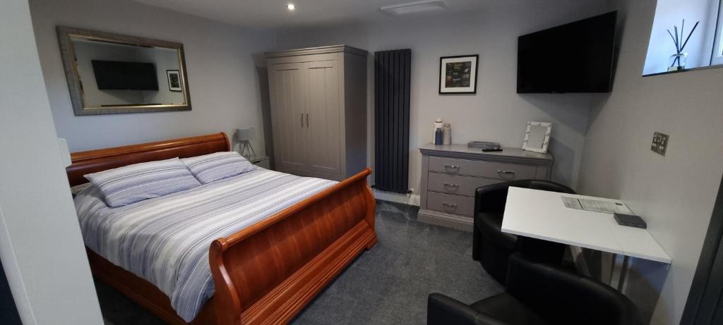 a bedroom with a bed and a desk and a television at The Nook in Rostrevor