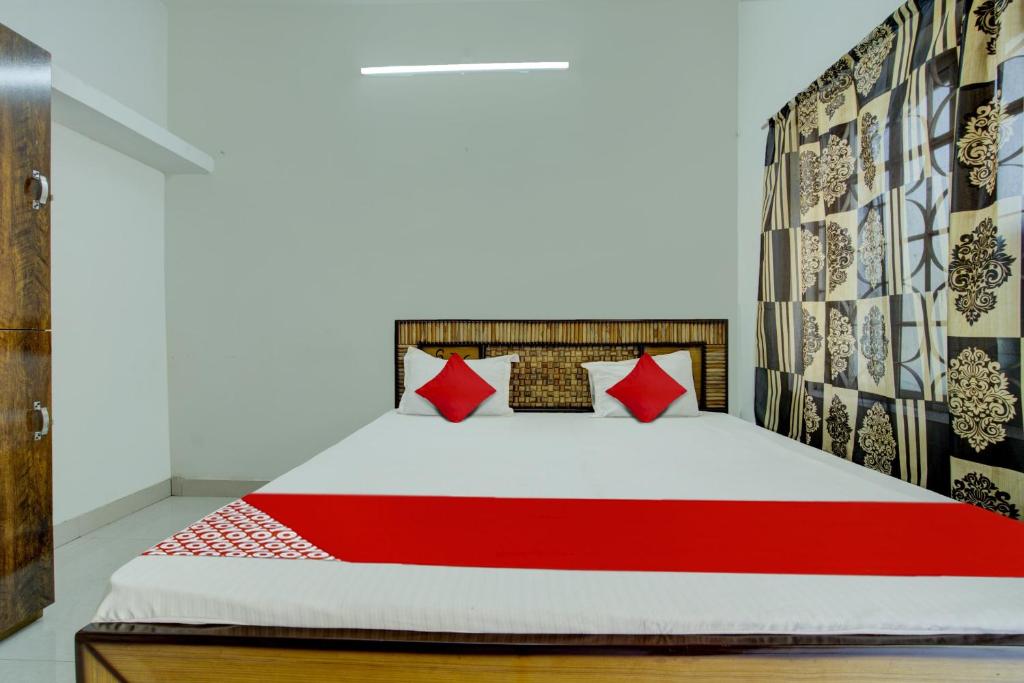 a bedroom with a bed with red pillows at Flagship Hotel Pragya 3 New in Raipur
