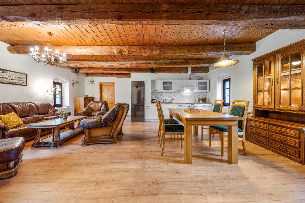 kuchnia i salon ze stołem i krzesłami w obiekcie Penzion Pršutérie® w Litomierzycych