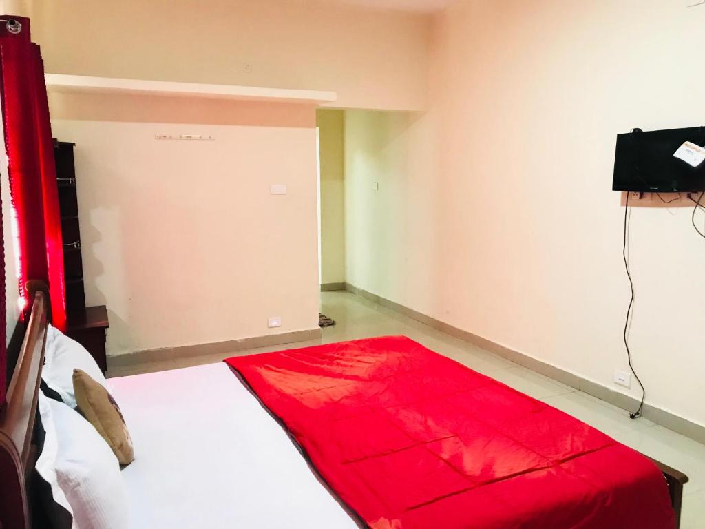 een kamer met een rode mat op de vloer bij NABA HOME STAY OOTY in Ooty