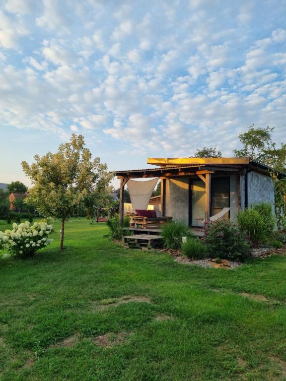 una pequeña casa en un campo con un patio de césped en Domki nad rzeką Ełk, en Prostki
