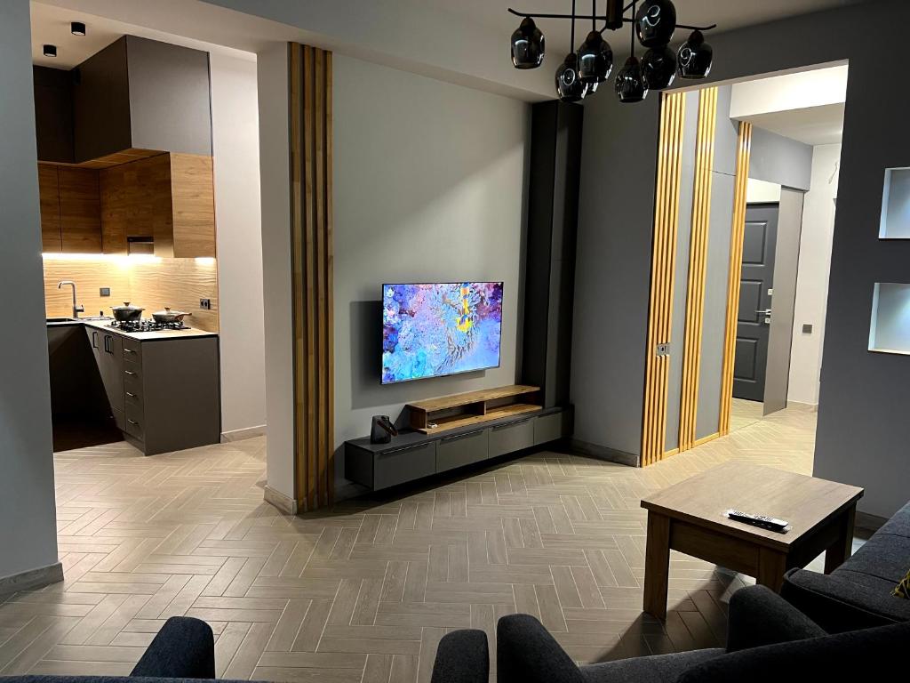 sala de estar con TV de pantalla plana en la pared en Modern Family Comfort: Yerevan/Wi-Fi, Balcony, AC, en Ereván