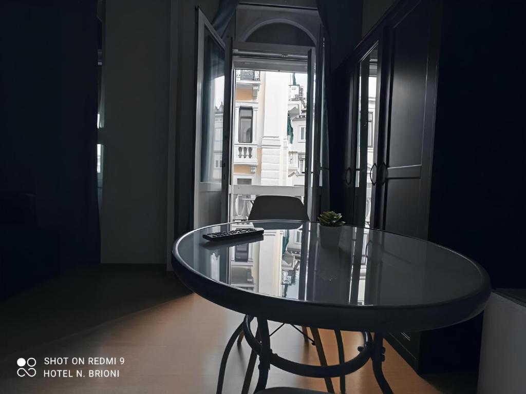 una mesa de cristal en una habitación con ventana en Hotel Brioni en Trieste