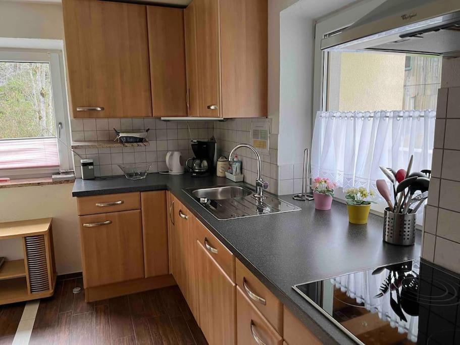 a kitchen with wooden cabinets and a sink and a window at Large 8 Bed Apartment. Perfect Location. in Stuhlfelden