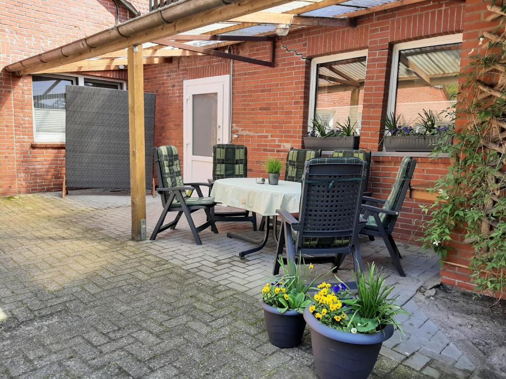 a patio with a table and chairs and a brick building at Ferienhof Schräder "Ol Huus unnern" in Papenburg