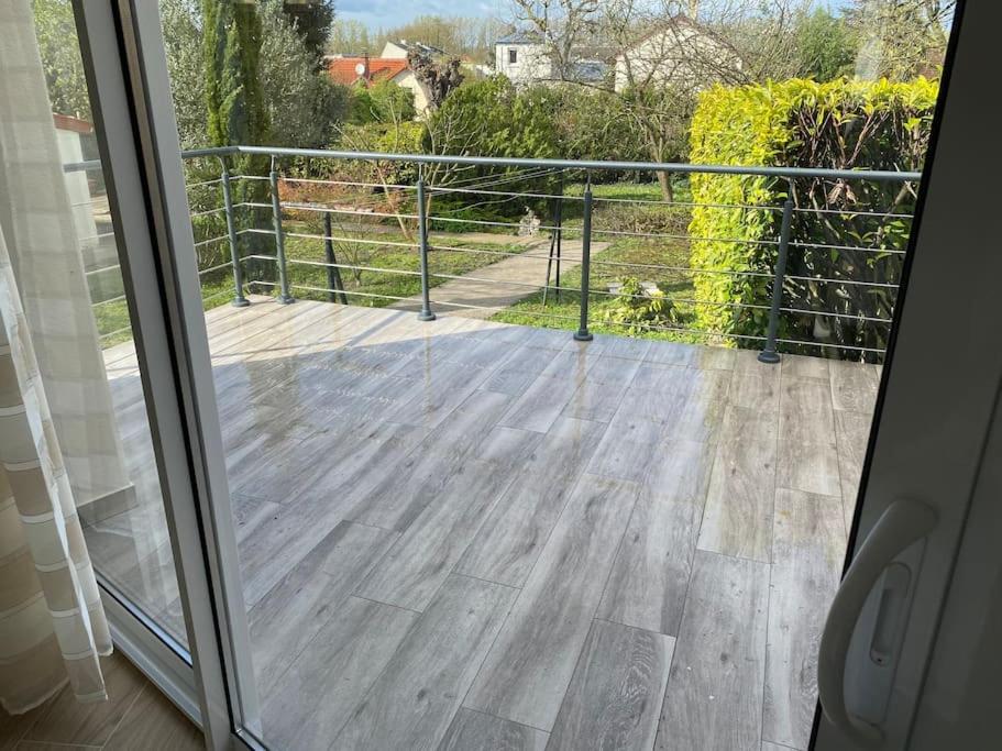 a sliding glass door with a view of a deck at Studio Les Oliviers in Noisy-le-Grand