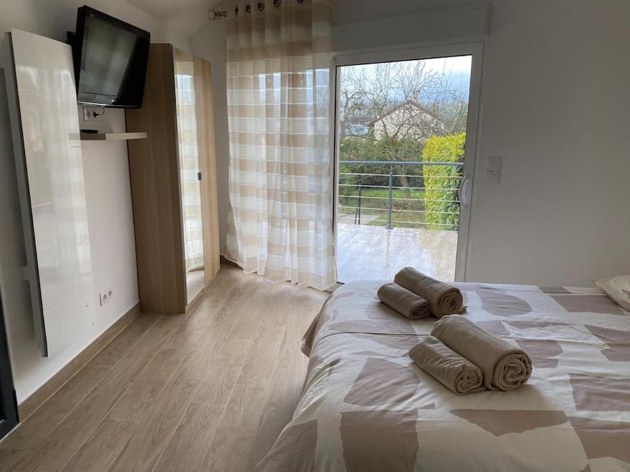 a bedroom with a large bed with three pillows on it at Studio Les Oliviers in Noisy-le-Grand