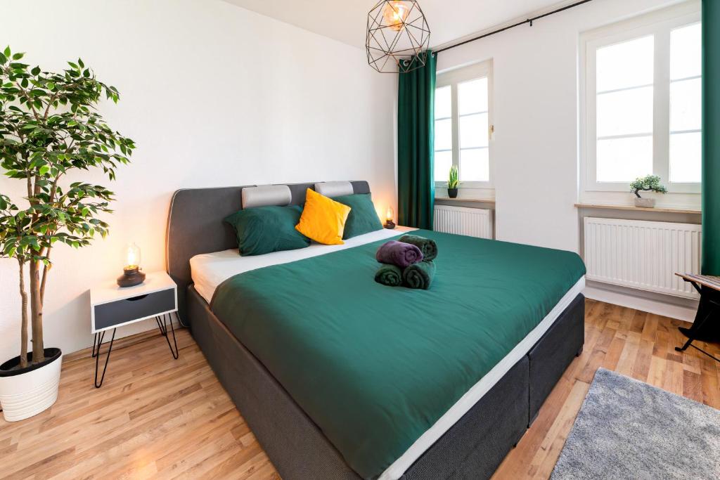 a bedroom with a large bed with green and yellow pillows at Perfect for 6 guests Kitchen Parking Netflix in Wuppertal