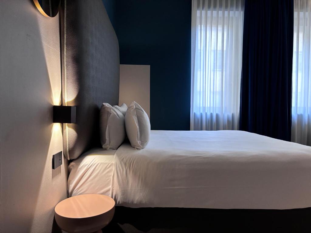 a hotel room with a white bed and a window at AV Hotel Milano in Milan