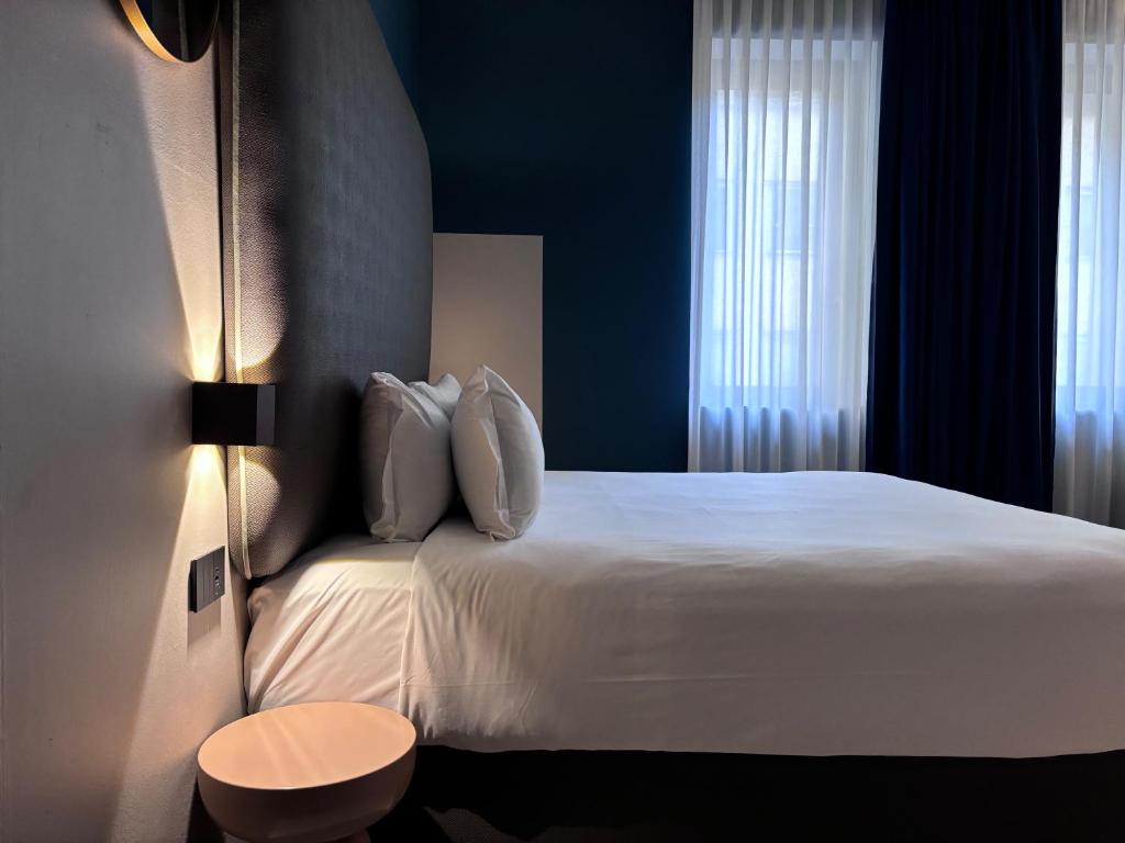 una camera d'albergo con un letto bianco e una finestra di AV Hotel Milano a Milano